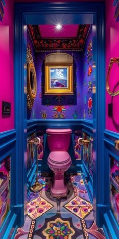 the bathroom is painted in bright colors and has a pink toilet with colorful decorations on it