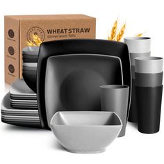 a black and white dinnerware set next to a cardboard box with wheat straw in it