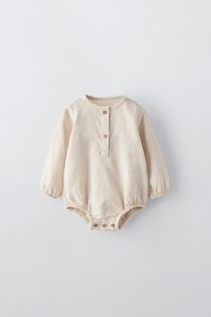 PLAIN BUTTONED BODYSUIT - Light beige | ZARA United States Solid Color Long Sleeve Onesie For Playwear, Solid Cotton Long Sleeve Bodysuit, Solid Long Sleeve Onesie For Playwear, Long Sleeve Solid Cotton Bodysuit, Solid Long Sleeve Cotton Bodysuit, Fall Long Sleeve Beige Bodysuit, Cotton Long Sleeve Onesie With Buttons, Cotton Long-sleeve Onesie With Buttons, Long Sleeve Cotton Onesie With Buttons