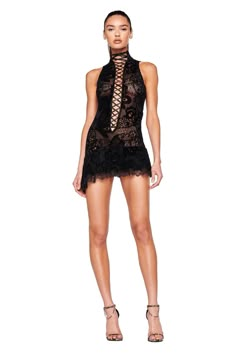 A woman stands wearing the PRISILLA MINI DRESS - BLACK : BURN OUT by I.AM.GIA, a short, sleeveless black lace dress featuring a high neck with crisscross lace-up detail down the front and a scalloped hem. She is also wearing high-heeled sandals as she poses confidently against a white background. Gisele Polaroid Dress, Las Vegas Club Dress, Detailed Black Dress, Velvet Burnout, I Am Gia, Burn Out, Festival Dress, Lace Ruffle, Skirts For Sale