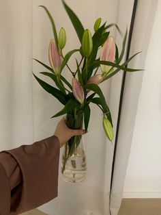 a person holding a vase with flowers in it