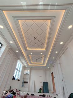 an empty room with white walls and ceiling tiles on the ceiling, while people are laying down