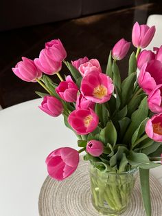 a vase filled with pink tulips on top of a table