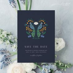 save the date card with blue and green floral design on it, surrounded by flowers