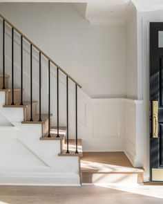 an empty room with white walls and stairs