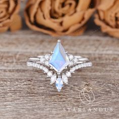 an engagement ring with a pear shaped blue topazte surrounded by white diamond accents