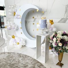 a table with a cake and flowers in front of a large letter sign that says happy birthday