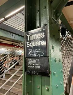 there is a sign that says times square on the side of a green metal structure