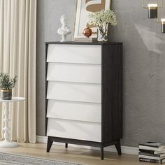 a white and black chest of drawers in a living room