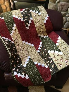 a red and green quilt sitting on top of a leather chair