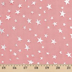 a ruler is next to a pink background with white stars