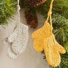 two knit mittens hanging from a christmas tree