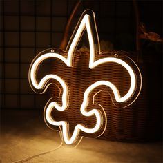 a light up fleur de lis sitting on top of a table next to a basket