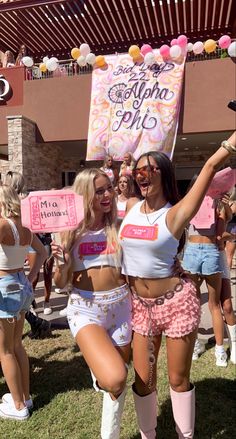 two women dressed in short shorts and knee high boots are holding up signs while standing next to each other