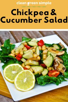 chicken and cucumber salad on a white plate with lemon wedges next to it