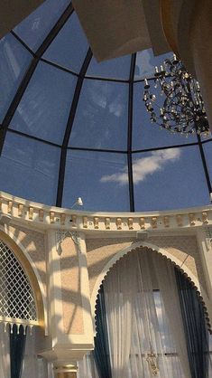 the inside of a large room with curtains and chandelier