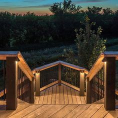 a wooden deck with lights on it and trees in the background