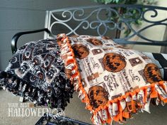 two black and orange umbrellas sitting on top of a metal chair next to each other