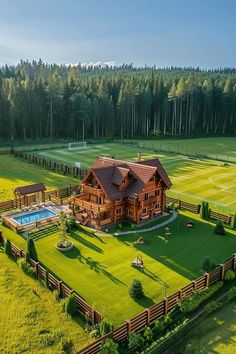 an aerial view of a large house in the middle of a field with a swimming pool