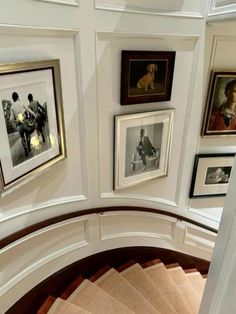 a spiral staircase with pictures on the wall