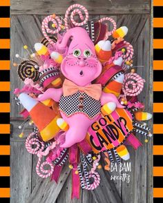 a wreath made to look like a pink troll with candy canes and candies