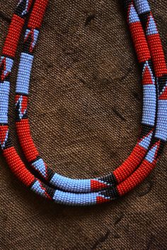 This statement-making tribal necklace is crafted from handmade beads. It is a beautiful and unique African Jewelry Collar, perfect for adding a bohemian touch to any look. Length: 10 inches Bohemian Handwoven Round Beads, Red Handwoven Bohemian Beads, Handwoven Red Bohemian Beads, Necklace African, African Jewelry, Collar Jewelry, Handmade Beads, West Africa, African Art