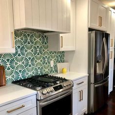 a stove top oven sitting inside of a kitchen next to white cupboards and drawers