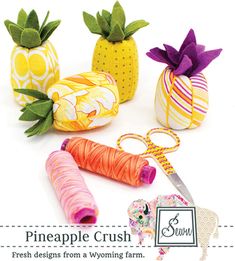 some pineapples are sitting next to each other with scissors and thread on them