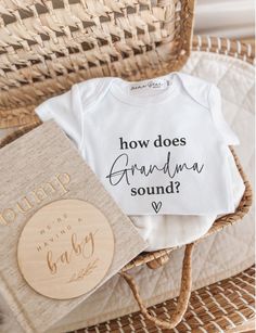 a baby's bodysuit and book sitting on top of a wicker chair