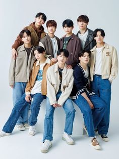 a group of young men standing next to each other in front of a white background