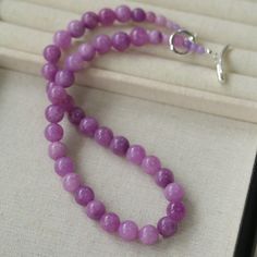 Embrace the essence of spring and summer with our Lavender Grapevine Gemstone Beaded Necklace! The enchanting purple hue exudes a blend of dreaminess and a hint of mystery. Crafted with romantic healing lavender gemstones delicately strung together, complemented by a minimalist OT clasp, this necklace embodies gentle elegance with a touch of individuality. Perfectly versatile, it effortlessly elevates any ensemble, whether paired with a solid-colored tee or a breezy resort sundress, exuding a charming Southern French allure. Metal: Recycled Sterling Silver Plated On Brass Gemstone: Natural Stone 10mm Length: 480mm Weight: 60g Lavender Crystal Necklaces With Natural Stones For Gift, Lavender Crystal Necklace With Natural Stones For Gift, Elegant Lavender Necklaces With Gemstone Beads, Elegant Lavender Necklaces With Natural Stones, Elegant Purple Beaded Necklace With Round Beads, Elegant Lavender Crystal Necklace With Round Beads, Purple Amethyst Round Bead Necklaces, Lavender Gemstone Beaded Necklaces As Gift, Purple Amethyst Gemstone Beaded Necklaces