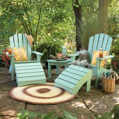 an outdoor area with chairs, tables and rugs in the middle of the yard