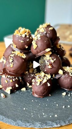 chocolate truffles piled on top of each other with nuts scattered around them and one being cut in half