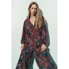 Full Length Jumpsuit With V-Neckline And Self Lined Buttons. Long Balloon Sleeves With Elastic Cuffs. 100% Polyester Red V-neck Jumpsuit For Fall, Red Printed V-neck Jumpsuits And Rompers, Red V-neck Jumpsuits And Rompers, Red V-neck Jumpsuits And Rompers For Loungewear, Chic Multicolor V-neck Jumpsuit And Romper, Chic Multicolor V-neck Jumpsuits And Rompers, Red V-neck Jumpsuit For Spring, Pink Printed V-neck Jumpsuits And Rompers, Red V-neck Jumpsuits And Rompers For Spring