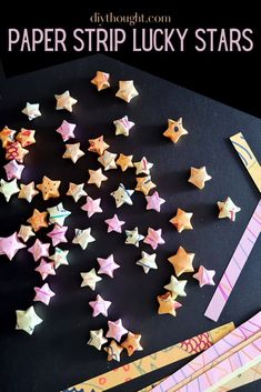 paper strip lucky stars are on the table next to scissors and pencils with text overlay that says paper strip lucky stars