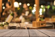 an empty wooden table with blurry lights in the background