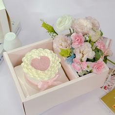 two cupcakes in a box with pink and white flowers