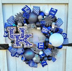 a wreath with the letter k on it and ornaments around it in front of a door