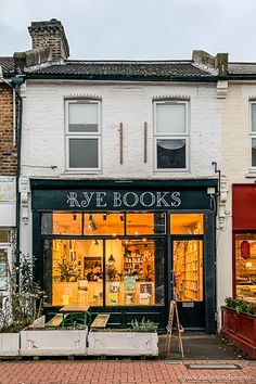 the storefront of ray books is lit up with bright lights and plants in front