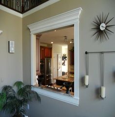 a living room filled with furniture and a large mirror on the wall next to a potted plant