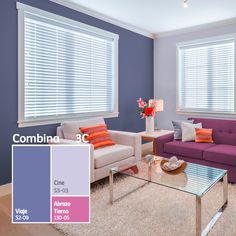 a living room with purple couches and orange pillows in the corner, along with white blinds