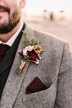 a man wearing a suit and tie with a boutonniere on his lapel