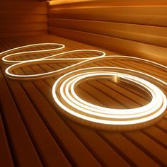 the inside of a sauna is lit up with white lights and circles on it