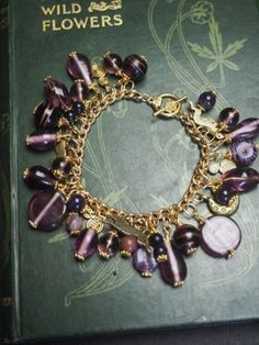 We love making these bracelets - each one is different - each charm is made from a purple tone glass or gemstone bead many vintage or up-cycled, along with a moon and hare charms. The charms are gold tone and hang from a gold plated chain measuring 8 inches long from end to end - we can alter it if needed for you by making it smaller, NOT larger - please check with us before you order so we can let you know how long this will take - usually only a day or two, you will lose a few charms doing this. It will come to you in a little hand made bag. It's a one of a kind item. This piece will be posted with First Class Mail within the US, if you need Priority, please select that at check-out instead. We offer generous postal discounts for multiple items purchased in one transaction - etsy should Hand Made Bag, Purple Tone, Moon Charm, Metal Charm, Gold Plated Chains, Bead Charms, The Moon, Gemstone Beads, Glass Beads