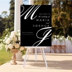 a welcome sign with white flowers and greenery in front of the entrance to a wedding venue