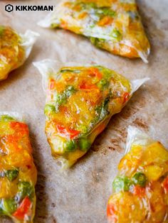 several pieces of food that have been placed on a baking sheet and are covered in plastic wrap