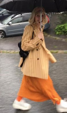 a woman walking down the street holding an umbrella