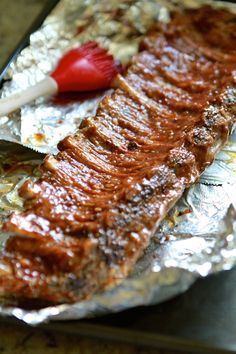 a piece of meat on tin foil with ketchup and a toothbrush in it