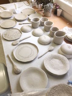 a table topped with white plates and bowls