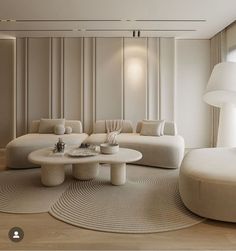 a living room with white couches and round tables in the middle of the room